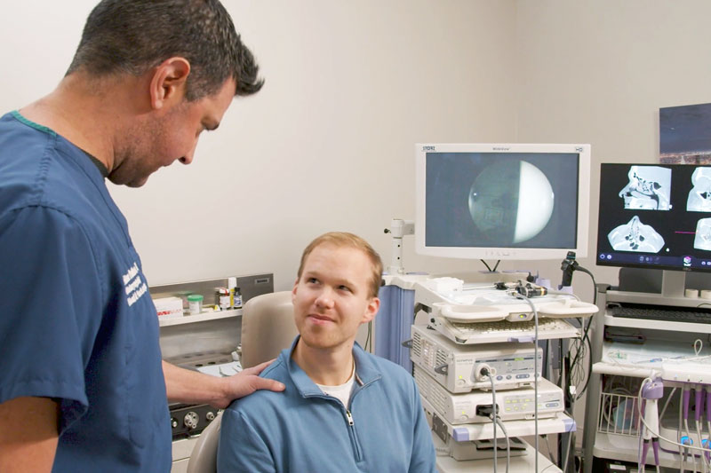 Male physician converses with patient in an ENT office prior to a procedure