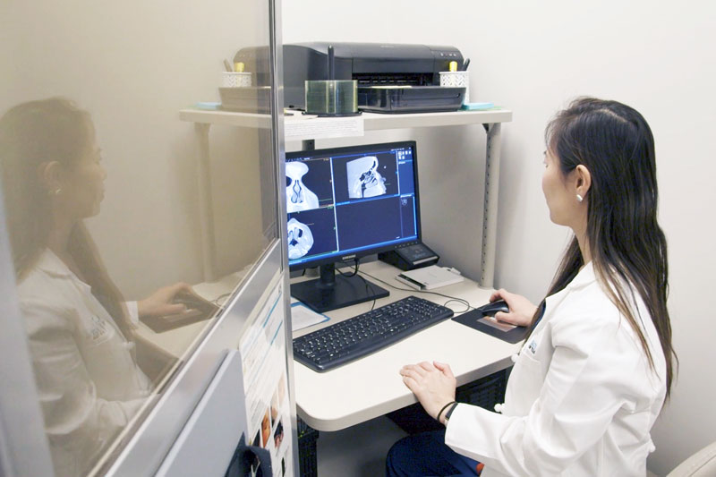 Dr. Dang looking at nasal screens on the monitor.