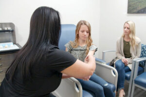 Medical team performing an allergy test on the forearm of a young female patient