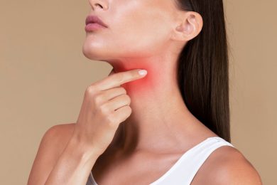 Woman rubbing a red inflamed part of her throat